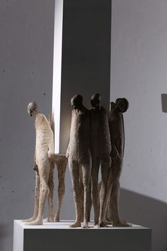 three sculptures are standing on top of a pedestal