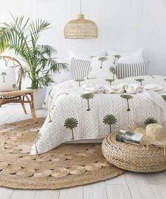 a bed with palm trees on it in a room next to a wicker basket