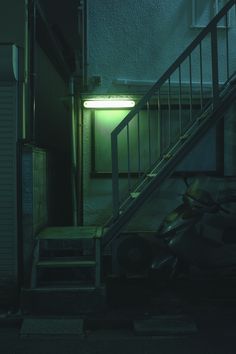 an image of a dark room with stairs and light coming from the door that is on