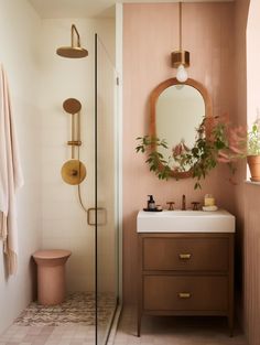 a bathroom with a sink, mirror and shower in it's center wall next to a toilet