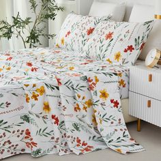 an image of a bed with flowers on the sheets and pillow cases that are not made