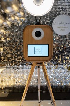 a camera on a tripod in front of a wall with disco balls and lights