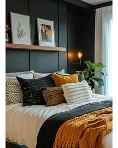 a bedroom with black walls, white bedding and yellow throw pillows on the bed