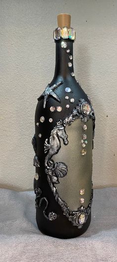 a black bottle with white and silver designs on it