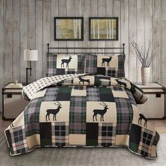 a bed covered in a checkered comforter and pillows with deer silhouettes on it