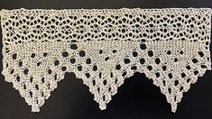 two pieces of crocheted lace on a black tablecloth with holes in the middle