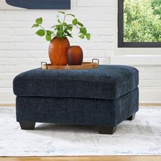 a blue ottoman with two vases on it