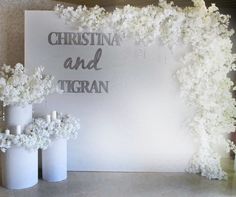 there are white flowers in vases next to a sign that says christina and tigran