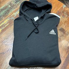 Black Adidas Hoodie With White Embroidered Logo On Left Chest And Three White Stripes On The Sleeves. Drawstring Hood With Front Pouch Pocket. Fleece Sweatshirt Hoodie With Three Stripes Branding, Adidas Hoodie With Three Stripes, Adidas Hoodie Sweatshirt With Three Stripes, Adidas Three Stripes Hoodie Sweatshirt, Adidas Casual Hoodie For Sports Season, Casual Black Hoodie With Fleece Lining, Casual Black Fleece-lined Hoodie, Adidas Fleece Hoodie For Sports, Black Cotton Sweatshirt With Fleece Lining