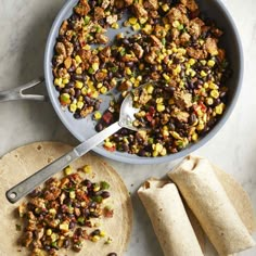 a pan filled with food next to tortillas