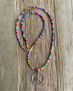 Spread good vibes wherever you go with this delightful peace sign necklace, handmade just for you. Crafted from gleaming sterling silver, the peace sign pendant hangs from a vibrant 16" necklace strung with colorful hippie love beads. https://kathybankston.com/products/peace-sign-necklace-with-hippie-love-beads Adjustable Multicolor Charm Necklaces Nickel Free, Adjustable Multicolor Nickel-free Charm Necklaces, Adjustable Charm Necklaces With Colorful Beads For Festivals, Adjustable Charm Necklace With Colorful Beads For Festivals, Adjustable Colorful Beads Charm Necklaces For Festivals, Adjustable Colorful Beads Charm Necklace For Festival, Bohemian Peace Sign Necklace For Gift, Silver Hippie Beaded Necklace For Festivals, Colorful Hippie Round Bead Jewelry