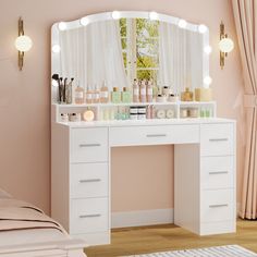 a white vanity with lights on it next to a bed and pink walls in a bedroom