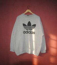 Up for sale Cool Vintage Adidas trefoil sweatshirt Good vintage condition, used sweater, show sign of normal wear, Overall in good vintage condition Tag size Adult Medium with actual measurement taken when lying flat armpit 24 inches and 27 inches in total lenght (Approx) Feel free to message me for measurements if you are not sure it will fit. Thank you! Tag Label: 1990s Adidas label Country of origin: Made in USA Feel free to e-mail me about any questions you have! Please review our shop polic Gray Sweater For Streetwear In Sportswear Style, Casual Adidas Logo Sweatshirt For Fall, Casual Adidas Sweatshirt For Fall, Long Sleeve Sweater For Streetwear With Branding, Long Sleeve Sweater For Streetwear, Casual Crew Sweater For Streetwear, Adidas Logo Cotton Sweatshirt For Winter, 90s Style Letter Print Sweater For Streetwear, Crew Neck Sweater For Streetwear