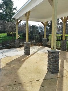 an outdoor covered patio with stone pillars