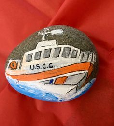 a painted rock with a boat on it and the words us c g written on it