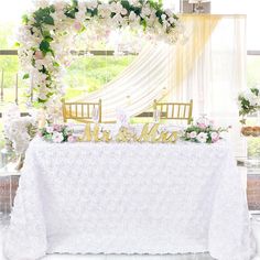 a white table topped with flowers and a mr and mrs sign