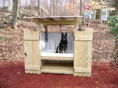 a dog is sitting in a small wooden structure