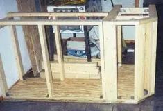 an unfinished entertainment center in the corner of a room