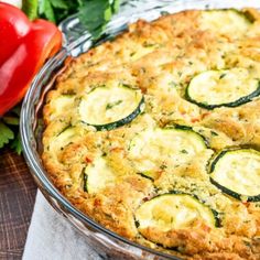 zucchini and cheese quiche in a glass pie dish on a wooden table