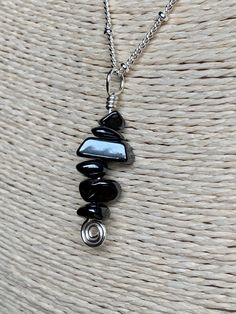 "Gemstone: Genuine Hematite Chips. Wire: Silver Plated with enamel coating to prevent tarnish and color change. Pendant Height: 1 3/8 inches. Pendant Width(at widest point): Approximately 1/4 inch in width (may vary due to the rough cut of the chips). Necklace Length: 18 inches. Necklace closure: Lobster. Necklace style: Satellite Chain. Chain Material: Silver plated brass. Hematite is an iron rich crystal with a gray, silvery color. When polished, it is almost reflective. Derived from the Latin Lobster Necklace, Chips Necklace, Cat Eye Bracelet, Necklace Closure, Cats Eye Ring, Gray Gemstones, Mermaid Glass, Selling Handmade Items, Iron Rich