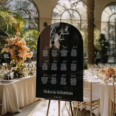 a table set up for an event with flowers and seating chart on the back side