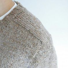 a close up of a person wearing a sweater with buttons on the collar and sleeves