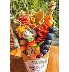 a bucket filled with lots of different types of food on top of a wooden table