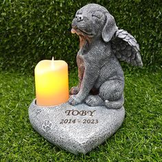 a memorial stone with a dog and candle on it