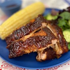 a plate with ribs and corn on the cob