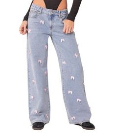 a woman wearing jeans with unicorns on them and a crop top over her shoulders