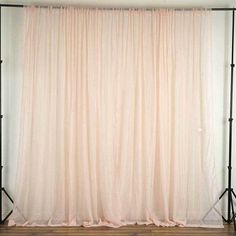 an empty photo studio with white curtains and black stands on the floor in front of it