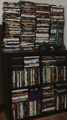 a book shelf filled with lots of books and dvds on top of it's sides