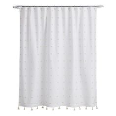 a white shower curtain with gold dots and tassels hanging from the top of it