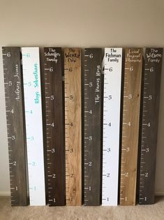 four wooden rulers are lined up against the wall, each measuring different heights and widths