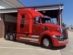 a red semi truck parked in front of a building