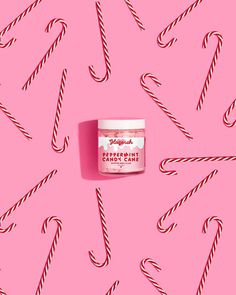 peppermint cream on pink background with candy canes