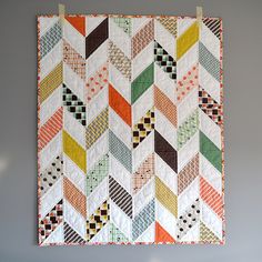 a multicolored quilt hanging on the wall