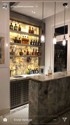 a kitchen with marble counter tops and shelves filled with liquor bottles on the back wall