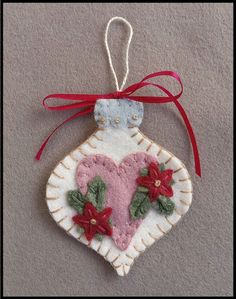 a heart shaped ornament hanging from a red ribbon