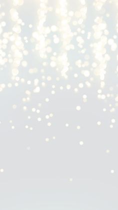 a blurry image of white bubbles floating in the air on a light gray background