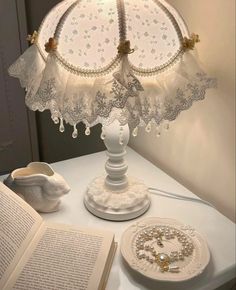 a lamp that is on top of a table next to an open book and plate