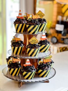 cupcakes are stacked on top of each other with construction signs and traffic cones