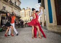 three women in red and white dancing on the street