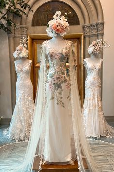 three mannequins dressed in wedding gowns with flowers on them