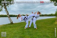 two women doing karate in front of a body of water with trees and clouds behind them