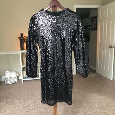 Woman’s Black Sequin Dress Size Medium. Never Worn And In Excellent Condition. The Dress Has Long Sleeves And Zips Up The Back Black Long Sleeve Sequin Dress For Holiday Party, Black Long Sleeve Sequin Dress For Spring, Black Sequin Dress For Holiday Party In Fall, Black Long Sleeve Sequin Dress For Date Night, Black Knee-length Sequin Dress For Night Out, Black Sequin Dress, Dress Medium, Black Sequins, Sequin Dress