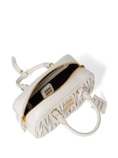 Find MIU MIU Arcadie Bag on Editorialist. The Miu Miu Arcadie bag is crafted from white cotton and leather with matelassé detailing. It features a top zip fastening, two top handles, logo lettering, gold-tone hardware, an adjustable detachable shoulder strap, a satin lining, and an internal zip-fastening pocket. The bag is a small, satchel style that can be worn on the shoulder or carried by hand. Luxury Miu Miu Shoulder Bag With Top Carry Handle, White Quilted Top Handle Bag, Luxury White Shoulder Bag With Zipper, Luxury White Shoulder Bag With Zipper Closure, Luxury Miu Miu Bags With Zipper Closure, Designer White Shoulder Bag With Zipper Closure, Luxury White Satchel With Zipper Closure, White Top Handle Satchel With Zipper Closure, White Luxury Bag With Zipper Closure