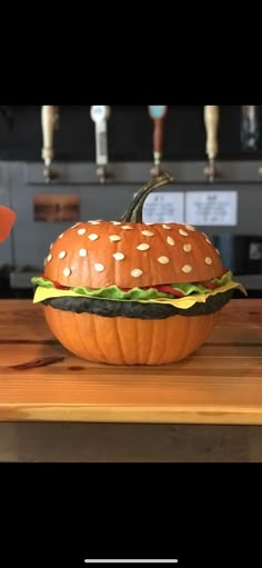 a pumpkin shaped like a hamburger sitting on top of a wooden table