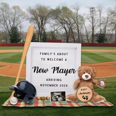 a teddy bear sitting on top of a blanket next to a baseball bat and glove