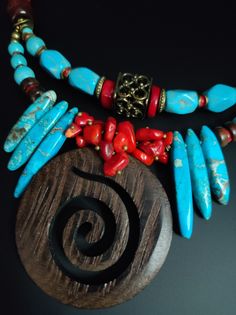 Beautiful ethnic style choker necklace, handmade with various materials: howlite, coral, jasper, hematite, wood. The central element of the necklace is a large pendant made of dark walnut-coloured cut-out wood. The turquoise blue of the jasper and the red of the coral contrast with each other and create a beautiful color combination. The necklace is double stranded, made up of different pearls and shells that create intersections of beautiful shapes and colors. The necklace is rigid but at the same time adheres perfectly to the neck and has an adjustable closure with a 7 cm extension. The necklace is very showy and colourful, in the colors of blue, red and brown, it is reminiscent of summer, the sea...suitable for a low-cut dress for a special occasion. It is a unique design created by me Different Pearls, Adjustable Multi-strand Turquoise Necklace With Colorful Beads, Turquoise Multi-strand Necklace With Large Beads, Choker Necklace Handmade, Southwestern Multi-strand Turquoise Necklace, Summer Choker, Handmade Multi-strand Red Coral Necklace, Beautiful Shapes, Turquoise Choker